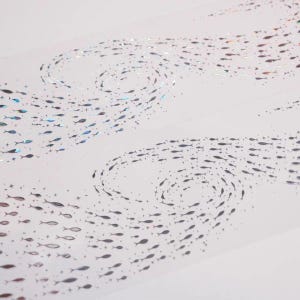 May include: Decorative tape featuring a repeating pattern of small fish in swirling formations. The fish are primarily silver with iridescent accents, creating a shimmering effect against the white background. The design evokes a sense of movement and the ocean.