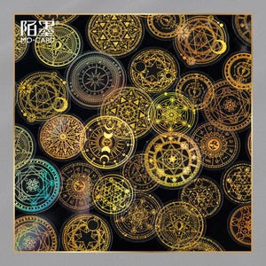May include: A collection of gold foil stickers featuring intricate geometric and celestial designs, including stars, moons, and compasses, on a black background. The stickers have a holographic effect and are arranged in a square format. The text "陌墨 MO-CARD" is visible.