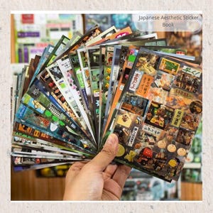 Inside pages of the Japanese retro sticker book showing assorted vintage café, street, and retro signs for journals and planners.