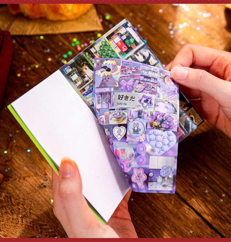 May include: A notebook with a green spine and white pages is held open, revealing a collage of purple and white stickers. The stickers feature various designs, including cartoon characters, bows, and floral patterns. Japanese text is visible on one of the stickers.