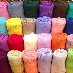 May include: A collection of 20 rolled fabric squares in various colors, including pink, blue, yellow, green, orange, and purple. The fabric squares are arranged in a basket.