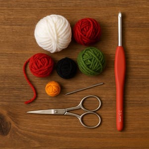 Op de afbeelding: Een verzameling haakbenodigdheden op een houten oppervlak. Inclusief witte, rode, zwarte, groene en oranje garenballen, een 2,5 mm haaknaald, een naald en een kleine zilveren schaar. De haaknaald heeft een rode handgreep.