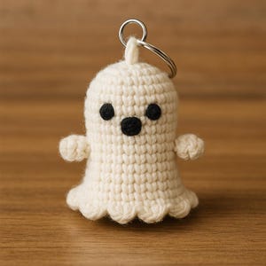 Puede incluir: Un llavero de fantasma de ganchillo hecho a mano, de color crema, con ojos y boca negros. El fantasma tiene brazos peque&ntilde;os y un borde inferior festoneado. Un llavero plateado est&aacute; unido a la parte superior. Un accesorio encantador y caprichoso.