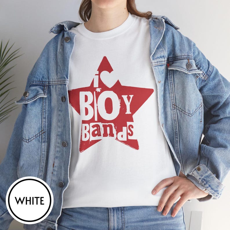 Puede incluir: Una camiseta blanca con un gr&aacute;fico de una estrella roja grande en el pecho. Dentro de la estrella, el texto blanco dice I heart BOY bands. La camiseta se lleva debajo de una chaqueta vaquera azul claro con botones met&aacute;licos y costuras.