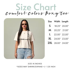 May include: A size chart for a Comfort Colors boxy tee, displaying a beige t-shirt with width and length measurement lines. A table lists sizes S through 2XL with dimensions in inches, noting that sizes may shrink or expand by 1.25 inches.