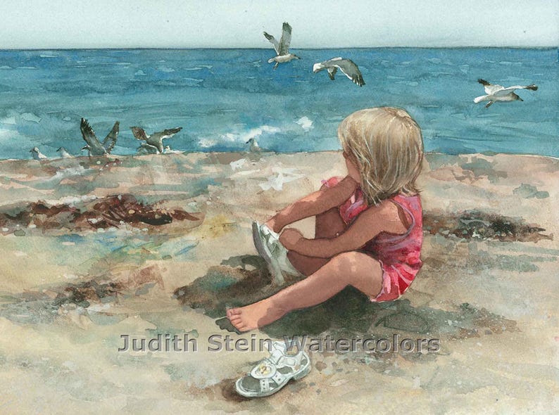 May include: A young girl in a pink dress sits on a sandy beach, putting on a white sandal. Seagulls fly overhead against a blue sky and ocean.