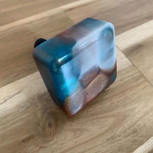 May include: A set of three ceramic mugs with a speckled, matte finish. The mugs are in shades of cream, light gray, and dark gray. Each mug has a simple, minimalist design, perfect for coffee or tea.