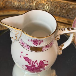 May include: A set of three ceramic mugs with a speckled, matte finish. The mugs are in shades of cream, light gray, and dark gray. Each mug has a simple, minimalist design, perfect for coffee or tea.