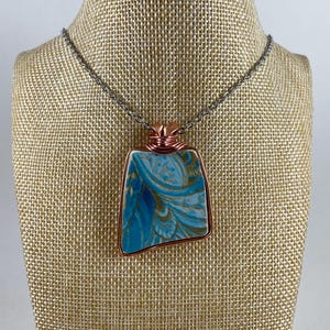 Pendentifs bijoux en porcelaine cassée recyclée avec fleurs bleu sarcelle, violettes et cuivre dans un cadre en cuivre