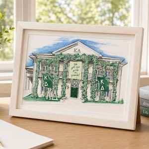 May include: A framed watercolor illustration of a two-story building with a pediment labeled KA, adorned with green vines. The building features green banners with the letters KA and a central banner with the text We got our girls in pearls.
