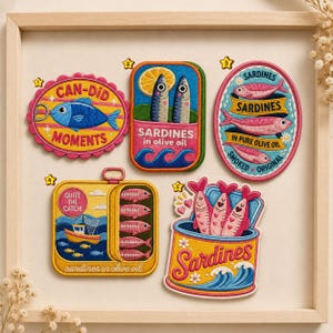 May include: Five embroidered patches featuring sardine themes. One oval patch says CAN-DID MOMENTS with a blue fish. A rectangular patch shows two fish and a lemon slice. An oval patch reads SARDINES IN PURE OLIVE OIL. A square patch shows a boat and fish. A tin-shaped patch says Sardines.
