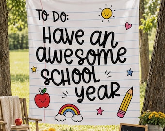Peut inclure: Une bannière en tissu blanc avec des lignes horizontales bleues rappelant une feuille de papier. Le texte indique TO DO: Have an awesome SCHOOL year en noir. Les illustrations incluent un soleil jaune, une pomme rouge, un arc-en-ciel et un crayon jaune.