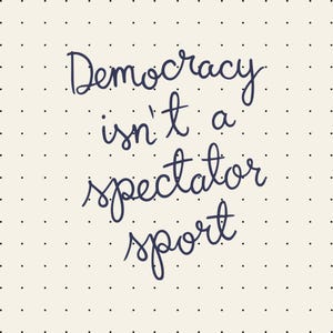 Può includere: Sfondo color crema con un motivo a piccoli punti neri. L'immagine presenta il testo scritto a mano "Democracy isn't a spectator sport" in corsivo blu scuro.