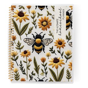 May include: A spiral-bound planner with a white cover featuring embroidered yellow sunflowers, green leaves, and a large bee. The text "THE ULTIMATE homeschool PLANNER" is printed vertically on a white label.