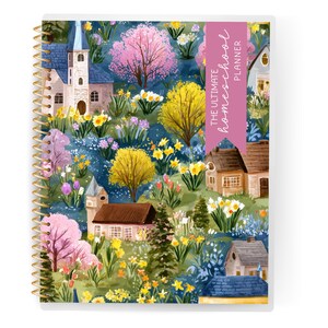 May include: A spiral-bound planner with a colorful cover featuring a whimsical village scene. The cover art includes houses, trees, and flowers in shades of pink, yellow, and blue. The text "THE ULTIMATE homeschool PLANNER" is displayed on a pink banner.