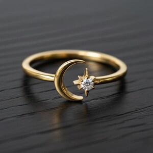 Peut inclure: Bague dorée ornée d'un croissant de lune et d'une étoile avec une pierre précieuse claire au centre. La bague a un design délicat et sur le thème céleste, parfait pour un usage quotidien.