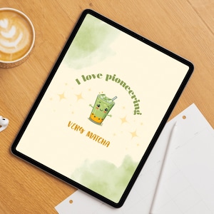 May include: A digital tablet shows a cartoon matcha drink with arms and a smiling face. The text reads "I love pioneering" and "Very Matcha" in green and orange. The background is a light yellow with green watercolour accents.