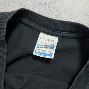 May include: Black XL t-shirt with a tag from Fruit of the Loom. The tag reads "SCREEN STARS" and "PREMIUM T". The shirt is made of 100% cotton and styled in the USA.