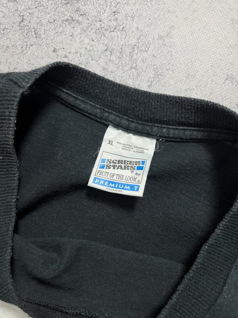 May include: Black XL t-shirt with a tag from Fruit of the Loom. The tag reads "SCREEN STARS" and "PREMIUM T". The shirt is made of 100% cotton and styled in the USA.