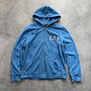 Peut inclure: Un sweat à capuche bleu clair avec fermeture éclair et poches avant. Le mot "GAP" est imprimé en blanc sur la poitrine. Le sweat à capuche est en matière douce.