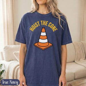 Navy t-shirt with orange traffic cone graphic and "Hoist the cone" text.