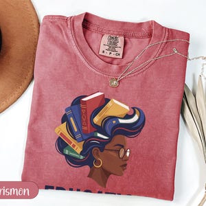 Crimson t-shirt with woman's profile and books in her hair, "Crismon" watermark.