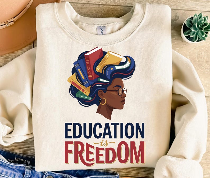 Cream sweatshirt with "Education is Freedom" graphic and woman with books in her hair.