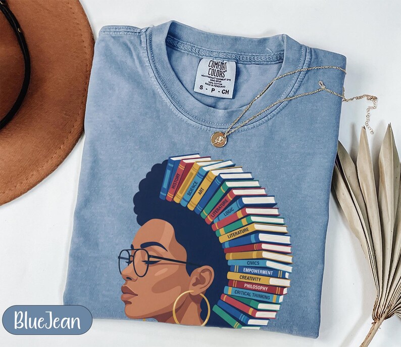 Blue t-shirt with woman's profile and spine of books representing subjects.