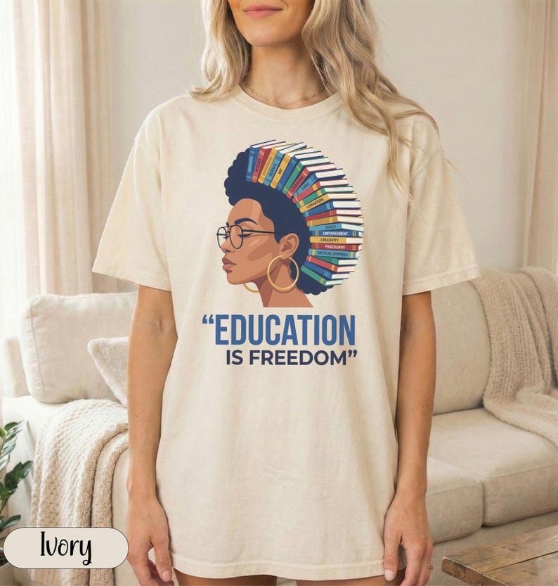 Woman with books as hair, quote "EDUCATION IS FREEDOM" on t-shirt.