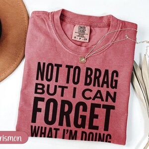 Crimson t-shirt with "Not to brag but I can forget what I'm doing" text.