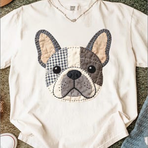 White t-shirt with a stitched French bulldog applique.