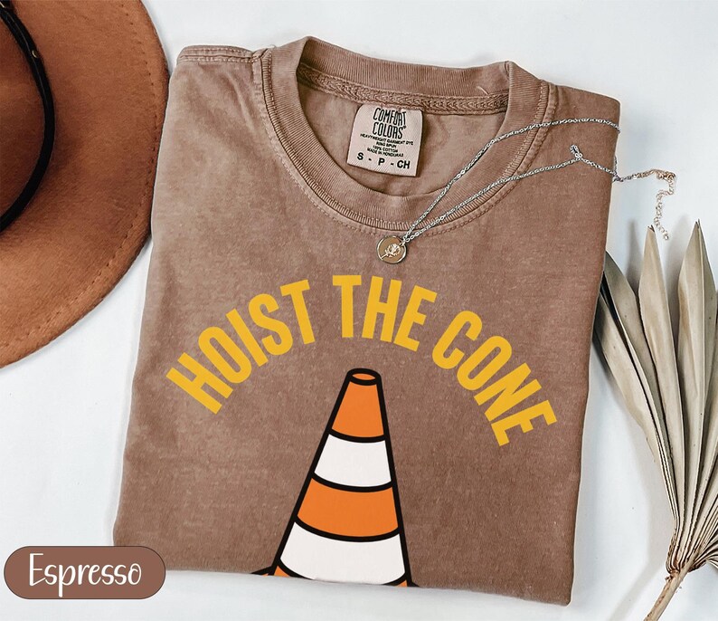 Brown t-shirt with "HOIST THE CONE" graphic and traffic cone.