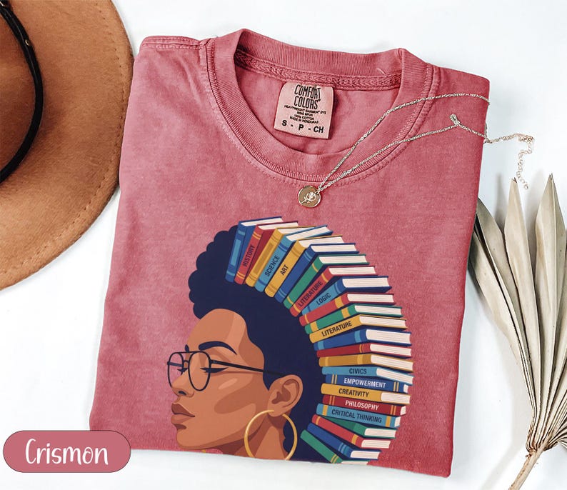 Red t-shirt with woman's profile, hair made of books with various subjects.