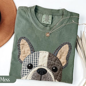 Green t-shirt with a patchwork French bulldog graphic, "Moss" text.