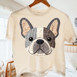 Cream t-shirt with a sewn French bulldog patch on the chest.