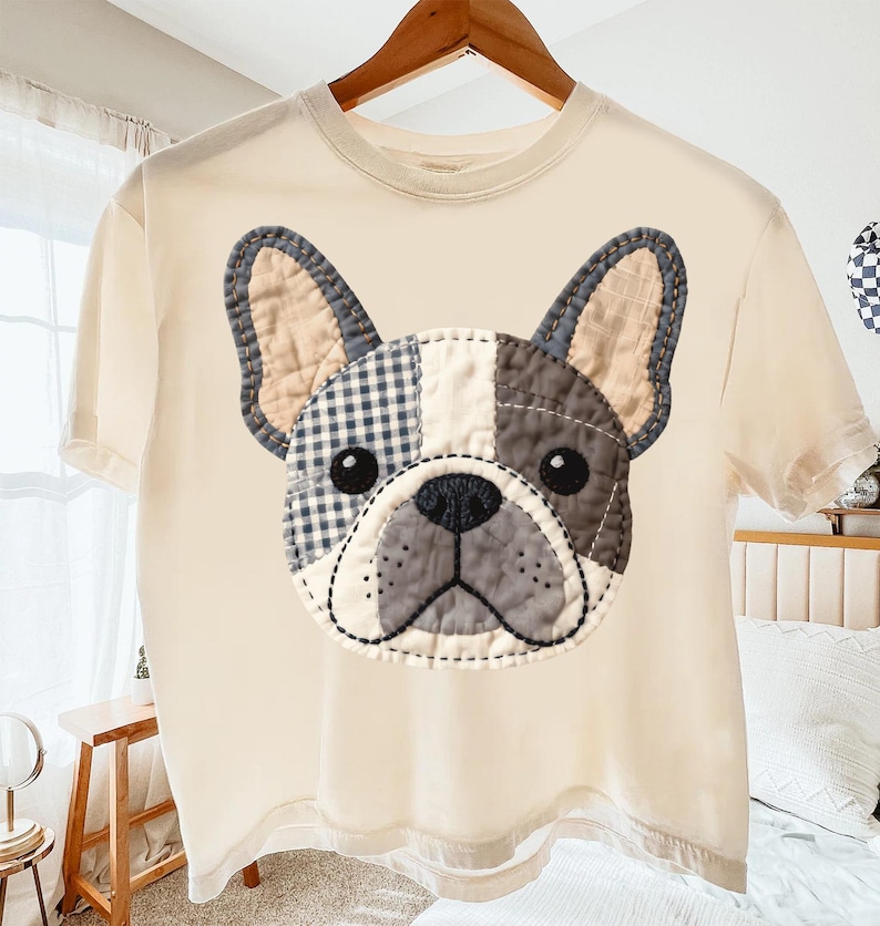 Cream t-shirt with a sewn French bulldog patch on the chest.