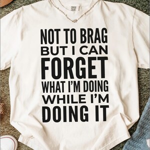 Cream t-shirt with "Not to brag but I can forget what I'm doing while I'm doing it" text.