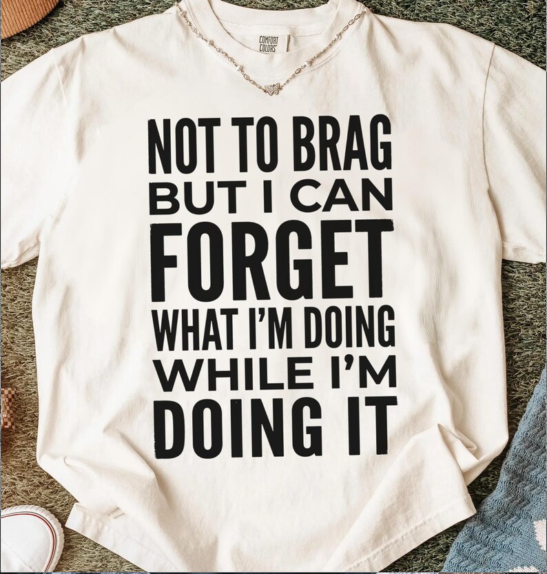 Cream t-shirt with "Not to brag but I can forget what I'm doing while I'm doing it" text.
