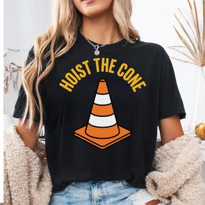 Black t-shirt with a graphic of an orange traffic cone and the text "Hoist the cone."