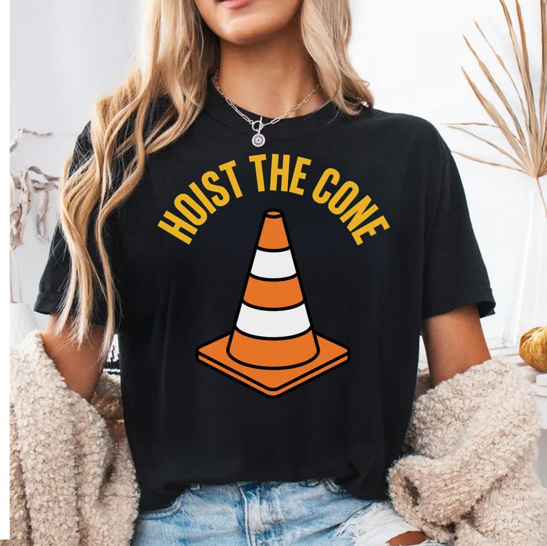 Black t-shirt with a graphic of an orange traffic cone and the text "Hoist the cone."