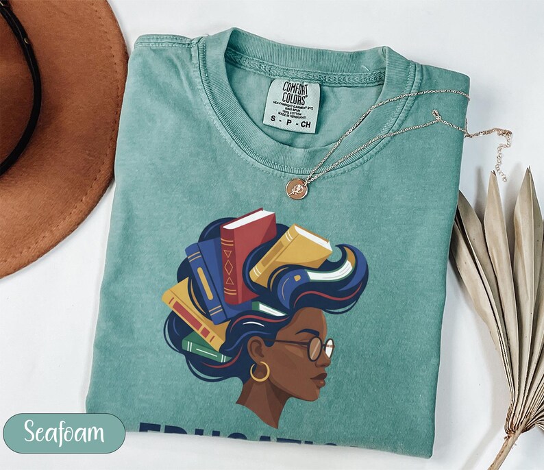 T-shirt with graphic of woman with books for hair, "Seafoam" text.