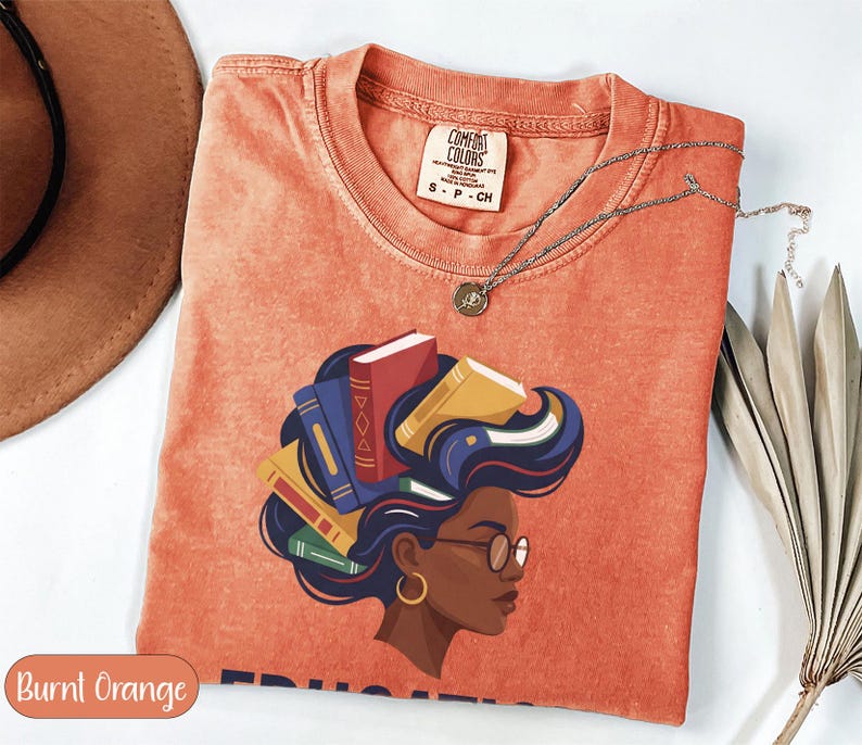 Orange t-shirt with graphic of woman with books for hair, Comfort Colors branding.