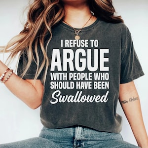 Op de afbeelding: Donkergrijs T-shirt met de witte tekst "I REFUSE TO ARGUE WITH PEOPLE WHO SHOULD HAVE BEEN SWALLOWED". Het T-shirt heeft een ronde hals en korte mouwen.