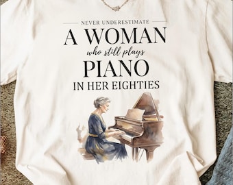 Never Underestimate Woman Who Plays Piano in Her Eighties T-Shirt, Elegant Watercolor Pianist Tee, Senior Musician Gift, Inspirational Quote