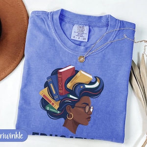 Periwinkle t-shirt with graphic of a woman's head with books for hair.