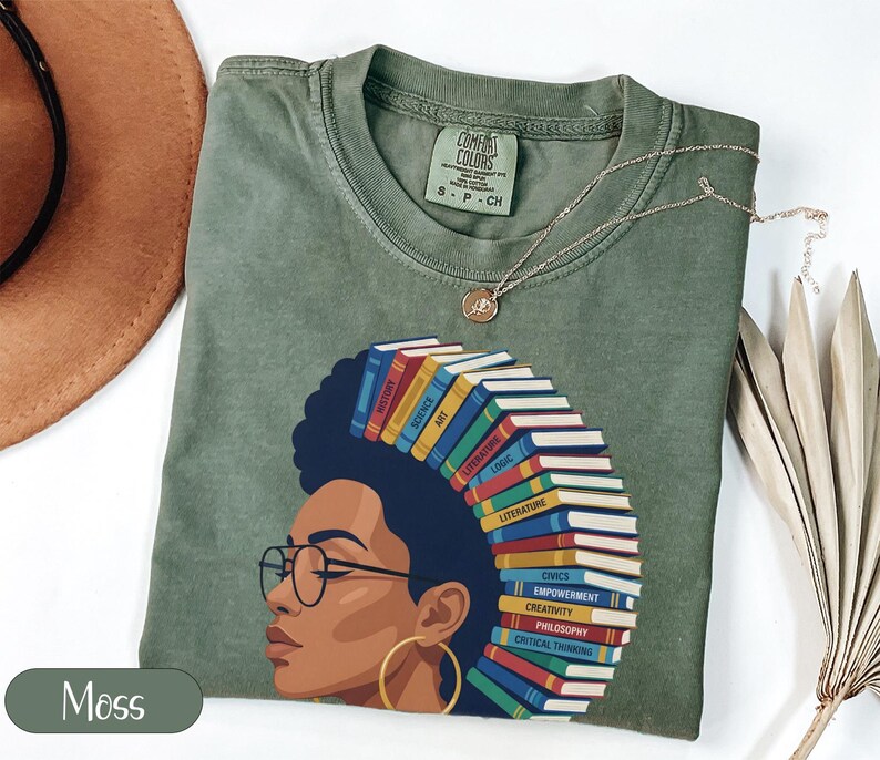 Green t-shirt with a graphic of a woman's profile adorned with books.