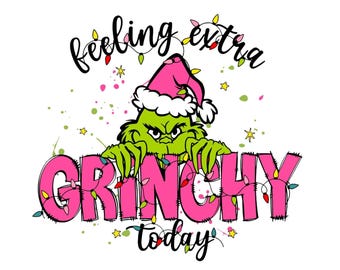 Può includere: Grafica festiva con il Grinch con un cappello da Babbo Natale rosa, con la frase "feeling extra Grinchy today". La parola "Grinchy" è rosa con luci fatate. Il Grinch è verde con un'espressione scontrosa.