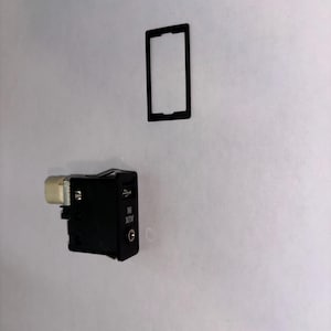 May include: A black car audio component with a USB port, an AUX IN port, and a rectangular black frame. The component has a white connector on one side.