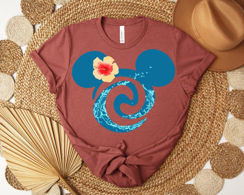 Puede incluir: Camiseta granate con un dise&ntilde;o de cabeza de Mickey Mouse azul, una flor y un remolino de agua. La camiseta est&aacute; hecha de material suave y es adecuada para uso casual.