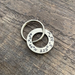May include: Silver key ring with a round tag engraved with the coordinates 44.4444 N 123.3233 W.